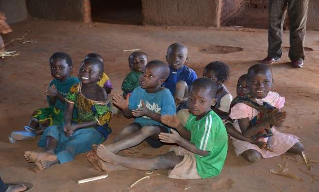 Children singing and clapping to a song at Chiweza II CBCC